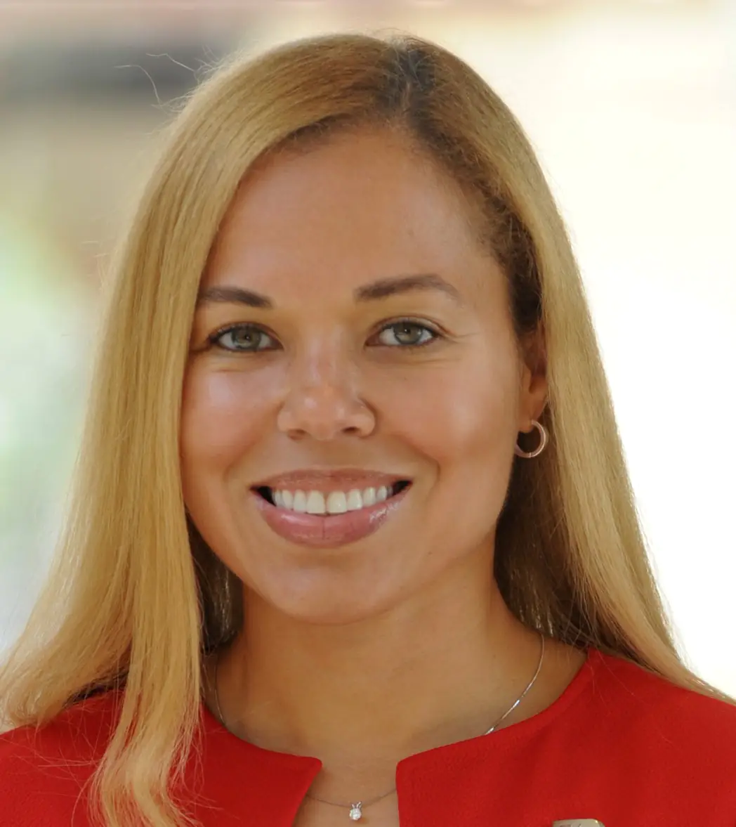 A portrait of Dawn Ofodile, a smiling woman with long blonde hair wearing a red top.