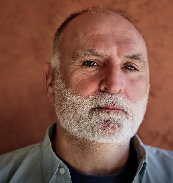 Portrait of José Andrés against a warm brown background.