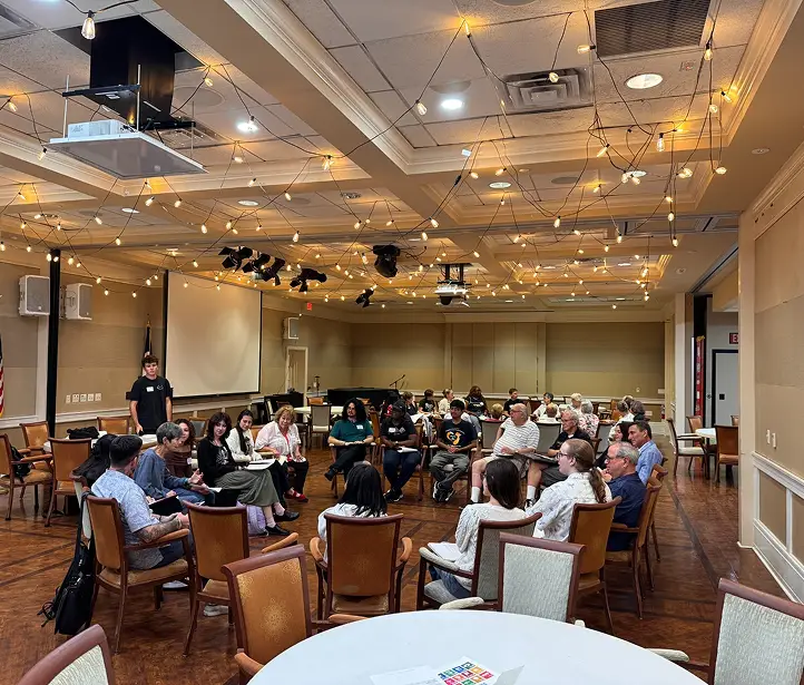 Younger and older adults seated in a circle for a Pages for the Ages group discussion.