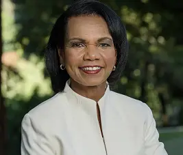 Condoleezza Rice smiling outdoors in a white jacket.