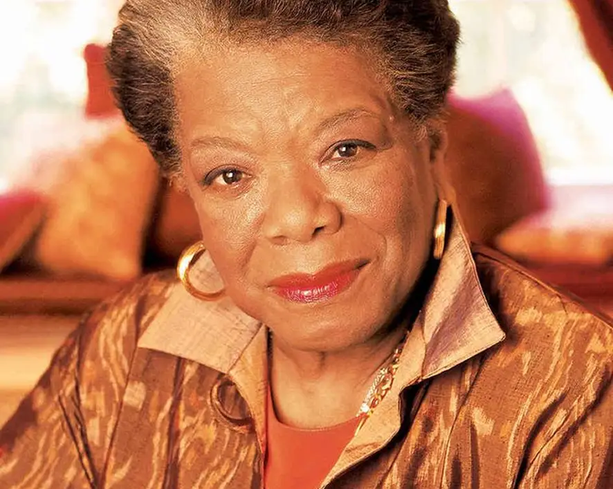 Portrait of Maya Angelou wearing gold hoop earrings and a patterned jacket.