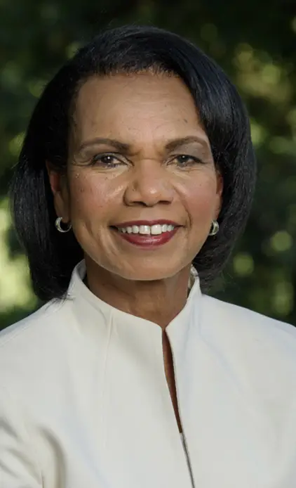 Condoleezza Rice smiling outdoors in a white jacket.