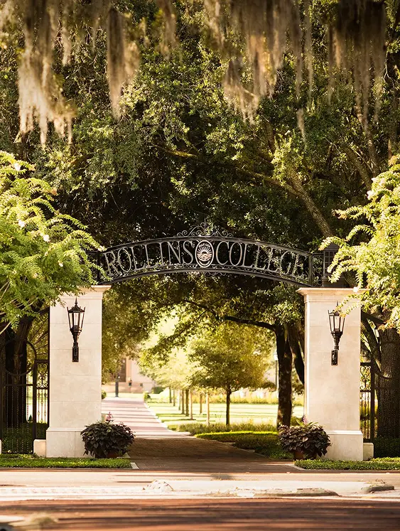 The Rollins College entrance arch framed by trees and hanging Spanish moss.