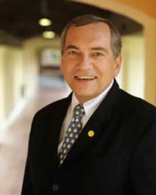 A man in a suit and patterned tie smiling at the camera for a Central Florida nonprofit.
